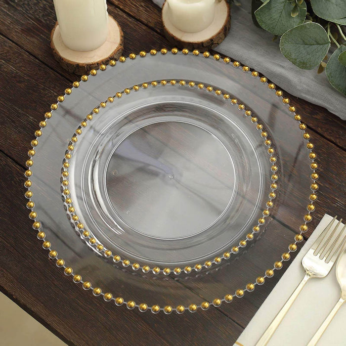 Clear decorative charger plate with gold bead accents on a rustic table setting.