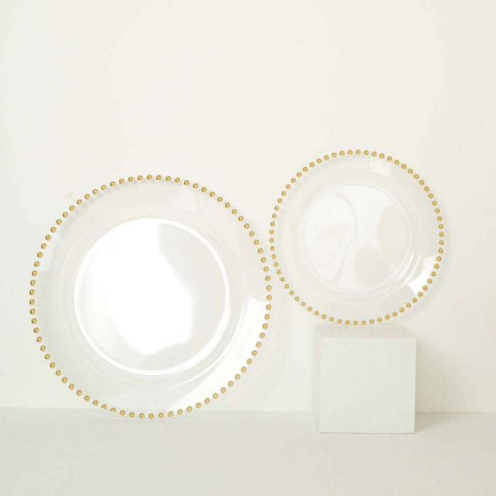 Elegant transparent plates with gold beaded rim on a plain background