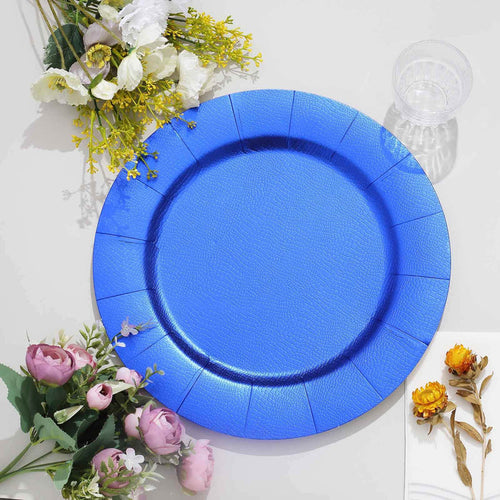 Blue disposable plate surrounded by colorful flowers on a white surface.