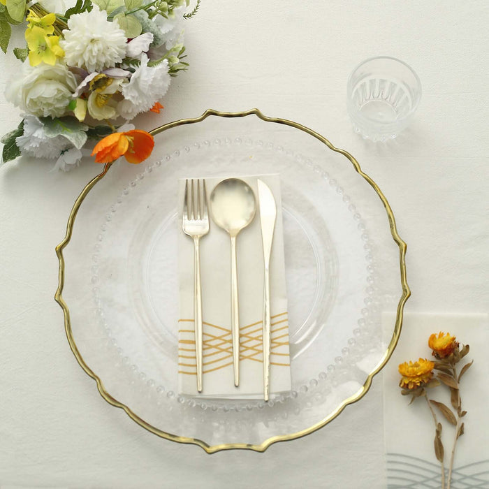 Elegant dining setup with gold-accented cutlery and floral decor.