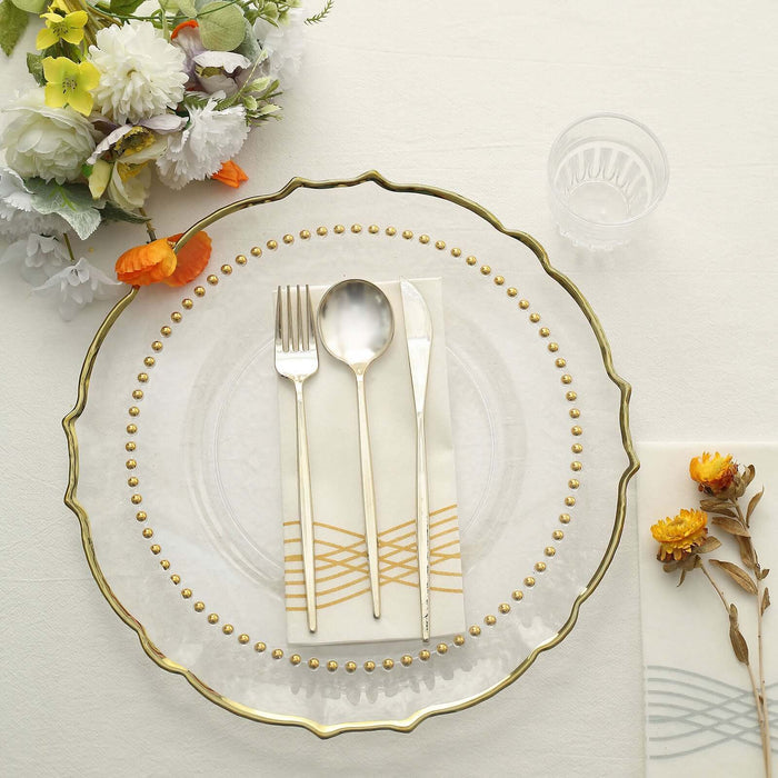 Elegant gold-trimmed glass plate with cutlery and decorative napkin