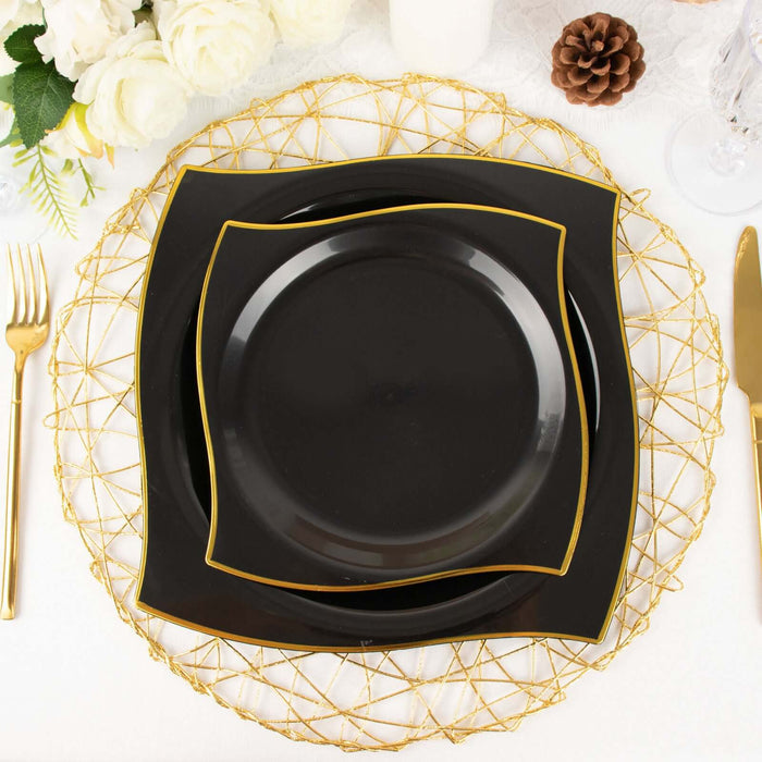 Elegant black dinner plates with gold trim on a decorative golden charger.