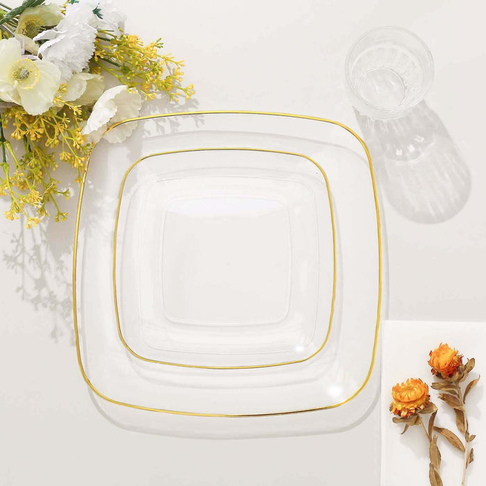 Three elegant glass plates with gold trim, styled with flowers.