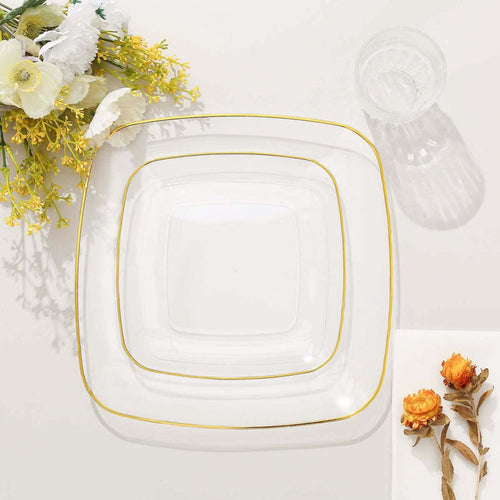 Three elegant glass plates with gold trim, styled with flowers.