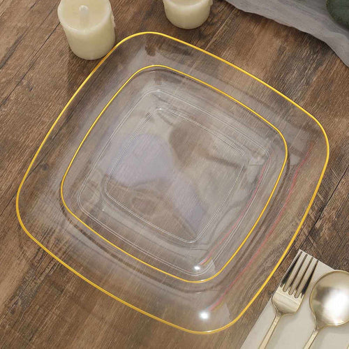 Clear square plate with gold trim on a wooden table setting.