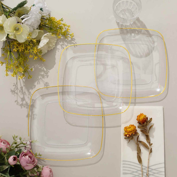 Clear glass plates with gold trim, arranged with floral decor.