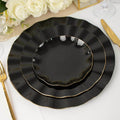 Elegant black plates with gold trim stacked on a table setting.