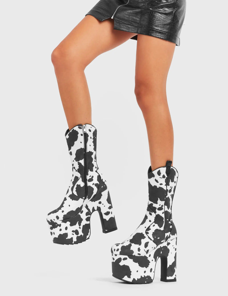 RINGING MEW
  
  Cowbell Chunky Platform Calf Boots in Cow Print faux suede. These vegan Platform Boots feature an ICONIC western cow print on a Chunky Platform sole and heel, the only choice for festival goers. Made with eco-friendly materials and 100% cruelty-free, these boots are as ethical as they are wild!
  
  
  - Platform Height: 
  - Heel Height:
  - Cowprint Design
  - Calf Length 
  - Black Zipper
  - Western Neck
  - Platform Sole
  - Pointed Toe
  - 100% vegan
  
  SKU: LMF 4921 - Cowprint