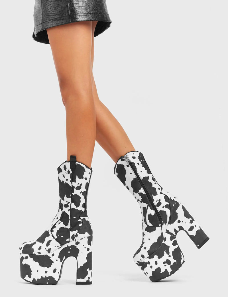 RINGING MEW
  
  Cowbell Chunky Platform Calf Boots in Cow Print faux suede. These vegan Platform Boots feature an ICONIC western cow print on a Chunky Platform sole and heel, the only choice for festival goers. Made with eco-friendly materials and 100% cruelty-free, these boots are as ethical as they are wild!
  
  
  - Platform Height: 
  - Heel Height:
  - Cowprint Design
  - Calf Length 
  - Black Zipper
  - Western Neck
  - Platform Sole
  - Pointed Toe
  - 100% vegan
  
  SKU: LMF 4921 - Cowprint
