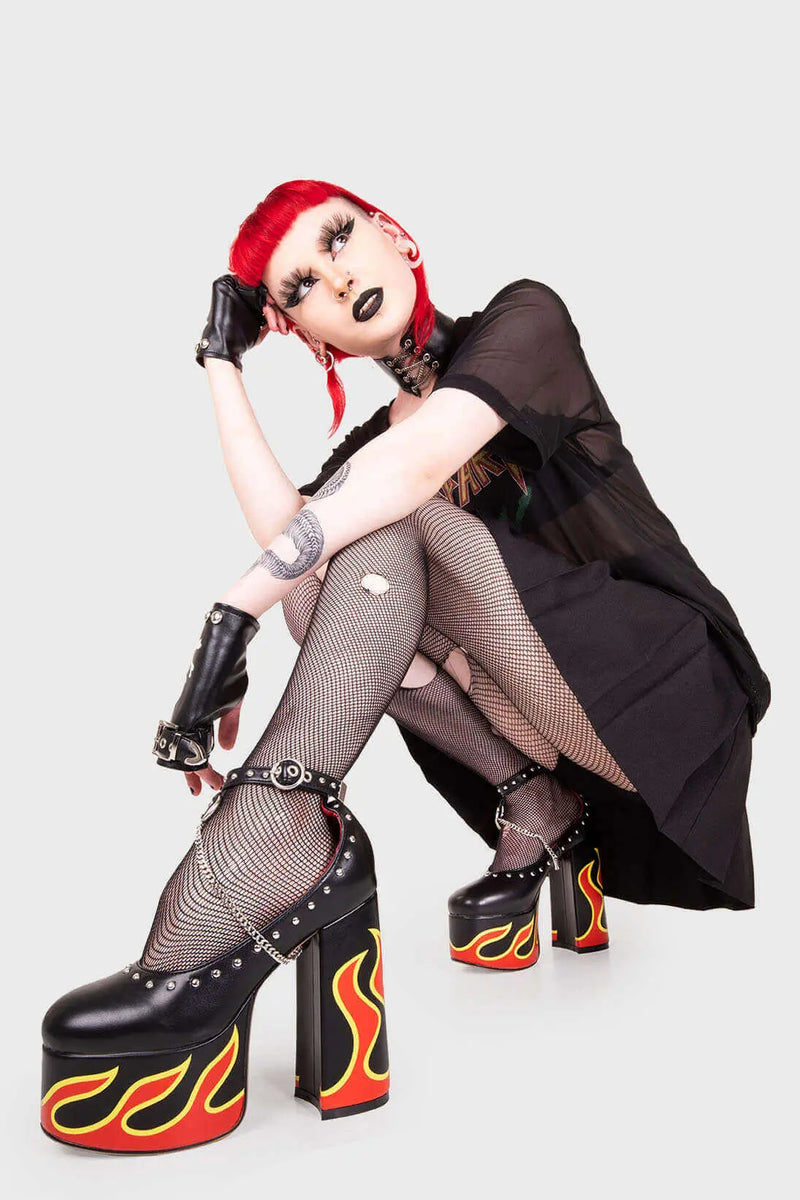 LIFE'S TOO SHORT FOR BORING HEELS
  
  Desire Platform Heels in Black faux leather. These vegan Platform Heels feature a flame print, silver studs and a high Platform sole and high heel, perfect for adding height, edge and glam to any outfit. Made with eco-friendly materials and 100% cruelty-free.
  
  - Platform Height: 2.5 inch
  - Heel Height: 5.5 inch
  - Silver studs & silver hanging chain
  - Adjustable ankle strap 
  - High platform sole
  - Round toe 
  - 100% vegan