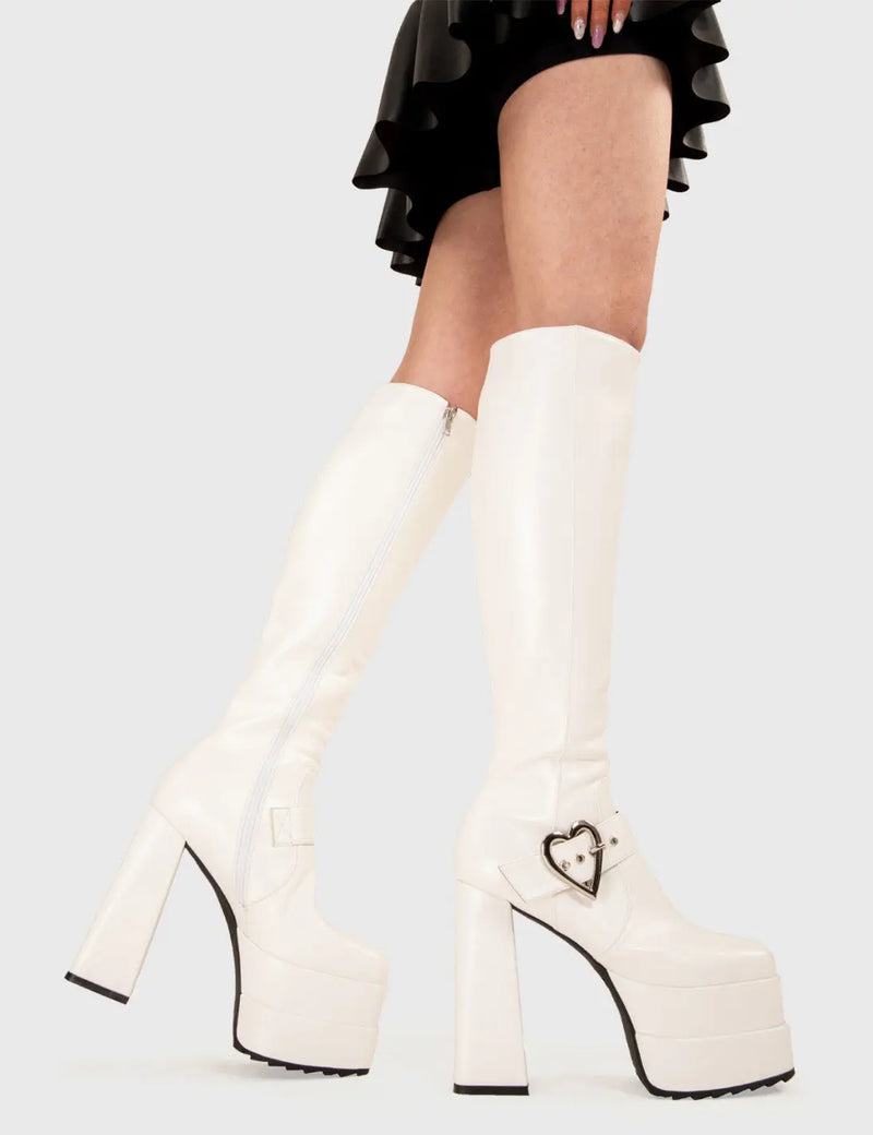 Walk in style!
  
  Fixed Up Platform Knee High Boots in White faux leather. These platform boots feature a silver heart-shaped buckle and strap, the perfect way to elevate any outfit. Made with eco-friendly materials and 100% cruelty-free, these platform boots are as ethical as they are eye-catching.
  
  - Platform Height
  - Heel Height
  - Silver heart buckle and eyelets
  - White zip
  - High Heel
  - Shark's Teeth Grip
  - 100% vegan 
  
  SKU: LMF 3188 - WhitePU