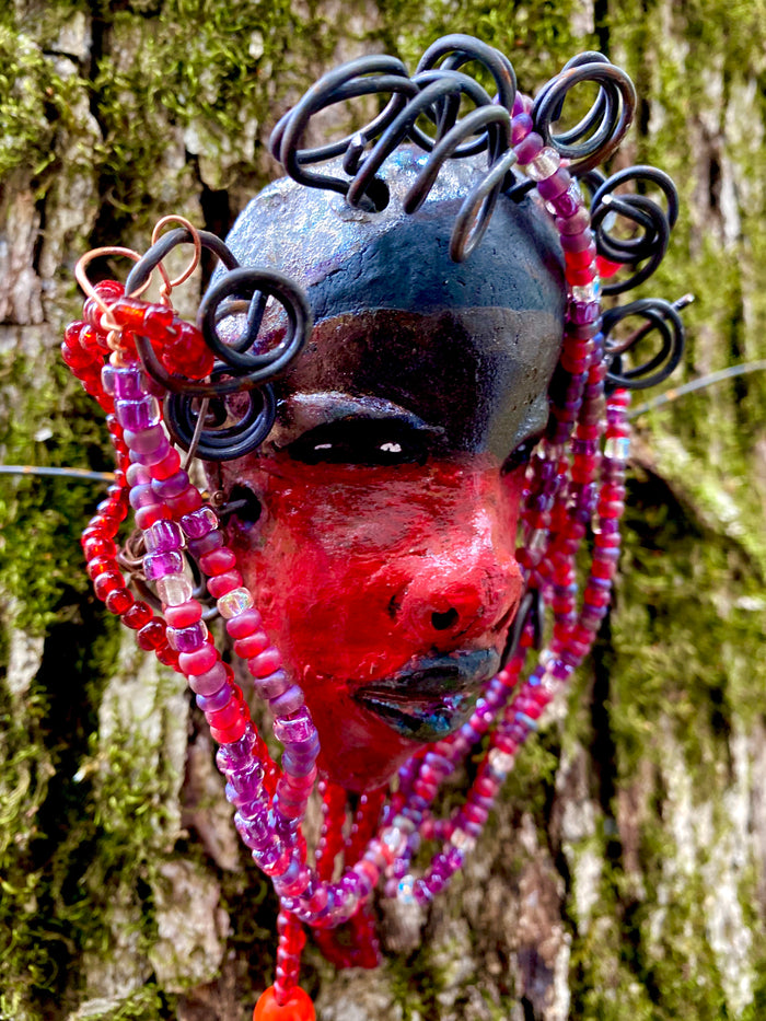 Meet Hariel! I started making art soon after seeing authentic African artwork at the Smithsonian Museum of African Art. I was in total awe. Jafari was inspired by my visit there.   Hariel has a two tone red and dark metallic copper complexion. She  is 6" x 4" and weighs 5 ozs. Hariel has over 4 feet of coiled 16 gauge wire hair and countless red mini beads..