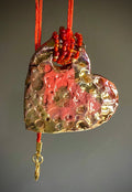 Have A Heart ! Each heart pendant is handmade with love! It is 3"x 3" and weighs approx. 3ozs. This pendant has a red violet and gold metallic raku glazes that renders a unique translucent  patina. The heart has a textured pattern . Both sides are  are different and equally beautiful! It holds a spiral of red violet mini beads on a spiral copper wire. This pendant has a nice 12" red suede cord!