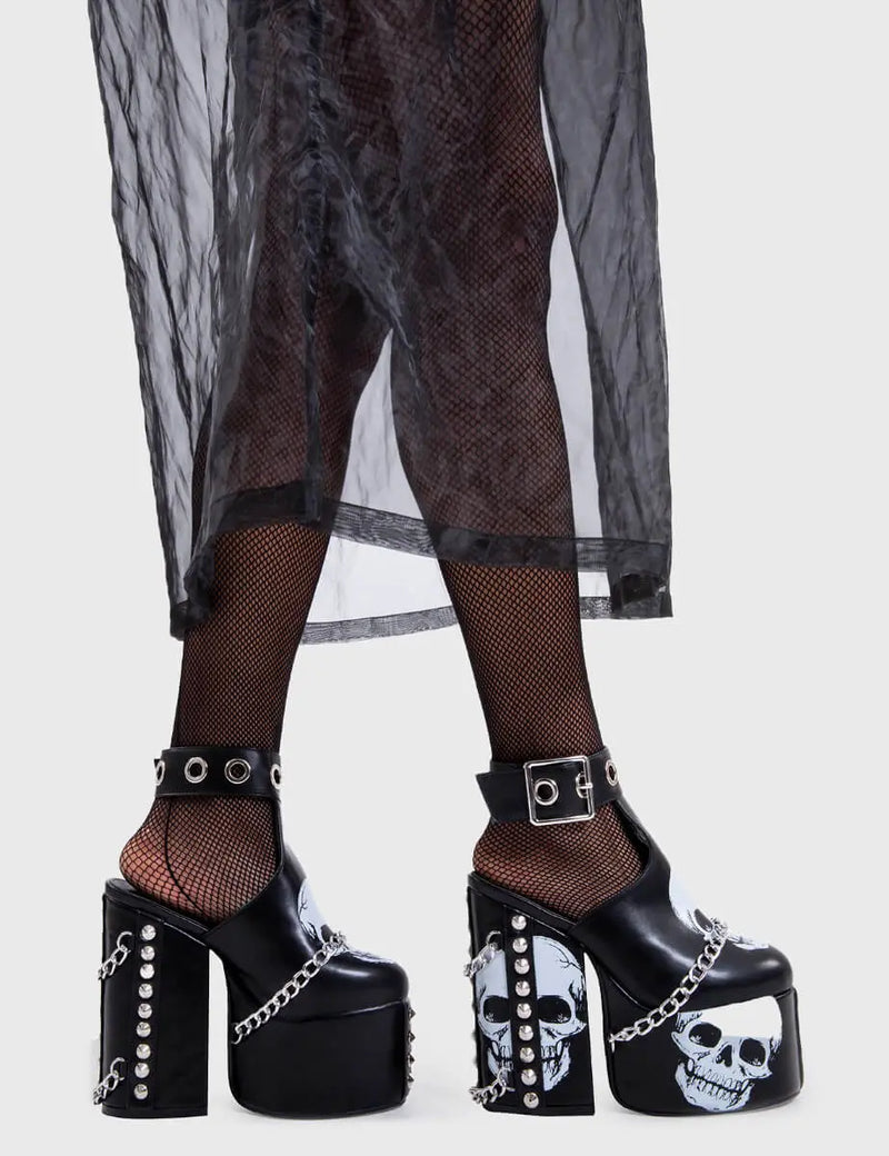 Skull Stomperss
  
  Hidden Closet Platform Heels in Black faux leather. These platform heels feature a skull design throughout and T bar structure ankle strap with square shaped buckle, make bold steps and leave a lasting impression.
  
  - Platform Height
  - Heel Height
  - Adjustable ankle strap
  - Silver eyelets and square shaped buckles
  - Skull design
  - Silver chain
  - Silver spiked studs
  - Chunky Platform sole
  - Round Toe 
  - 100% vegan