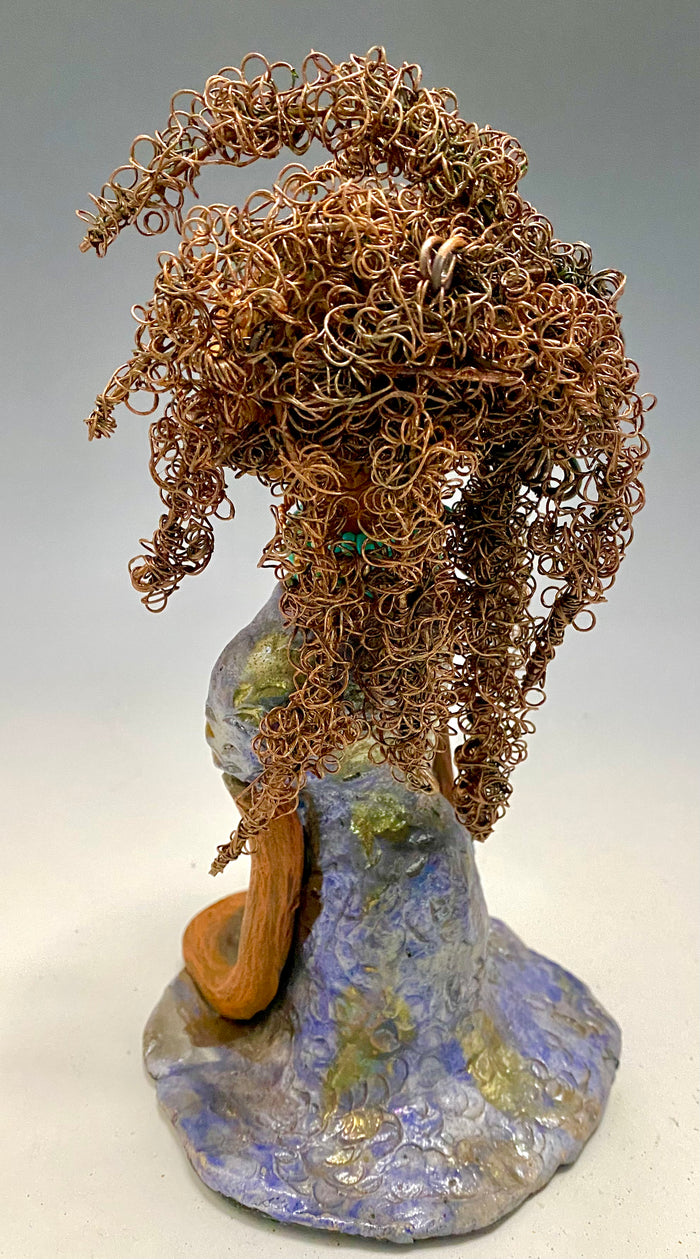 Meet Janae'! She has grown a head full of Hair! Janae' stands 8" x 5" x 4" and weighs 1.03 lbs. She has a lovely honey brown complexion with lovely reddish brown lips. Janae' wears a clay braided hairstyle. Janae' has a colorful metallic blue and gold glazed dress. She wears a blue and antique copper  beaded necklace. With eyes wide opened, Janae' has hopes of finding a new home.