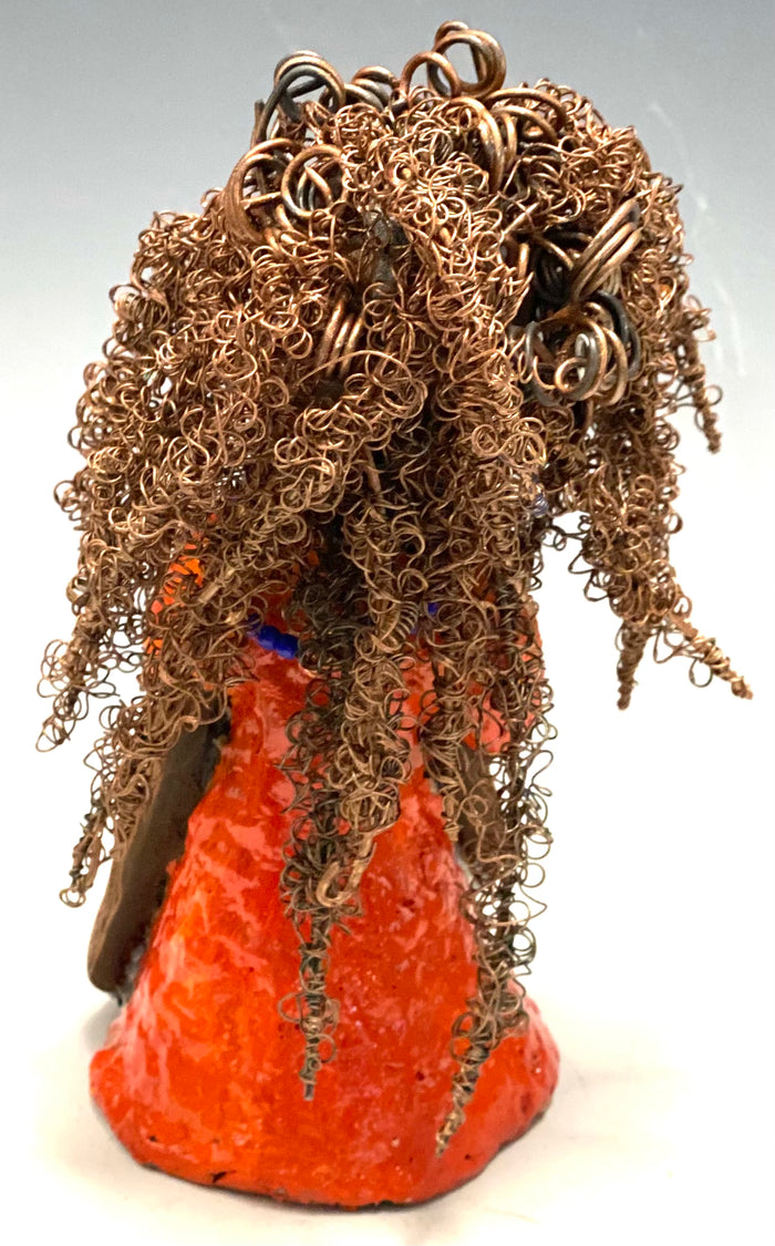 Meet Jada! Jada stands 8" x 3.5" x 3.5" and weighs 1 lb. She has a lovely honey brown complexion. Jada's dress is simply bright orange. She has her long loving arms resting at her side. " I am really pleased with Jada's blue beaded necklace and her new wire hair Find a place in your space for Jada!