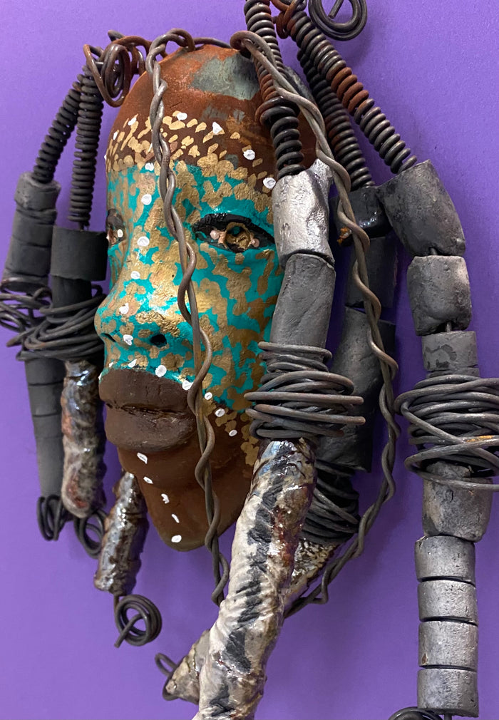 Meet Kanumba! I started making art soon after seeing authentic African artwork at the Smithsonian Museum of African Art. I was in total awe. Kanumba was inspired by my visit there.   Kanumba has an awesome earthy green tribal scarification complexion. He is approximately 8" x 8" and weighs 13 ozs. Kanumba has an handmade textured off white clay and metallic dreadlocks along with twist of coiled 16 gauge wire.