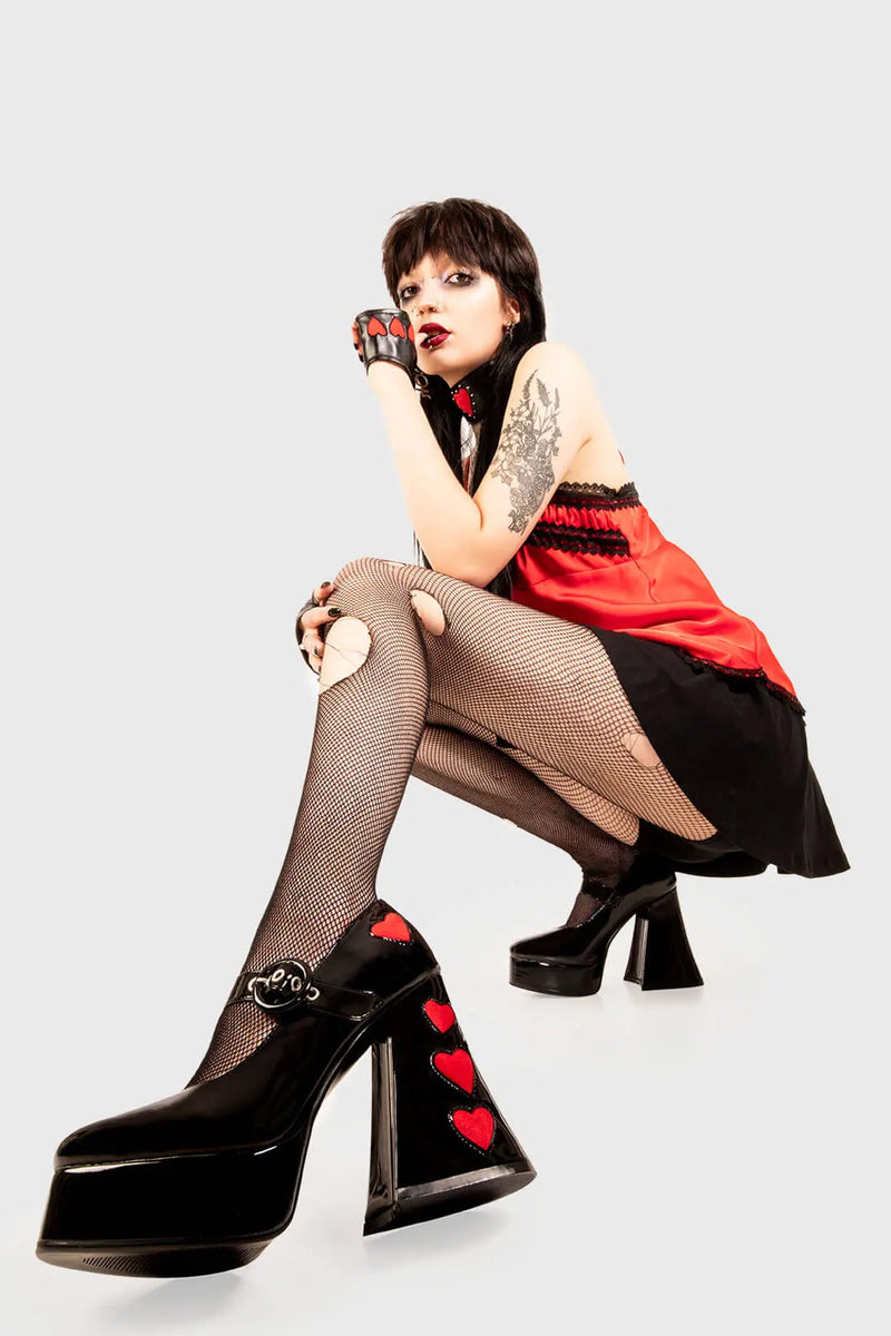 Cupid is here 
  
  Love Sick Platform Heels in Black Patent faux leather. These vegan Platform Heels feature pink patent hearts on the heel and side of the shoe with a adjustable black strap, Heels that speak the language of love. 
  
  - Platform Height: 2.6 inch
  - Heel Height: 5.5 inch
  - Ajustable strap 
  - "O" ring shaped buckles and silver eyelets
  - Pink Patent hearts 
  - Platform sole
  - Flared heel
  - Round toe 
  - 100% vegan
  
  SKU: LMF 1709 - BlackPAT/RedHeart