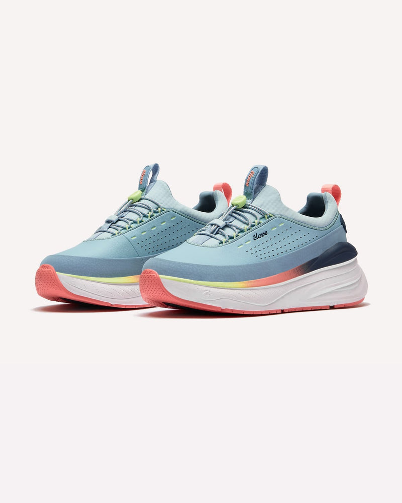 Pair of light blue running shoes with colorful soles on a white background