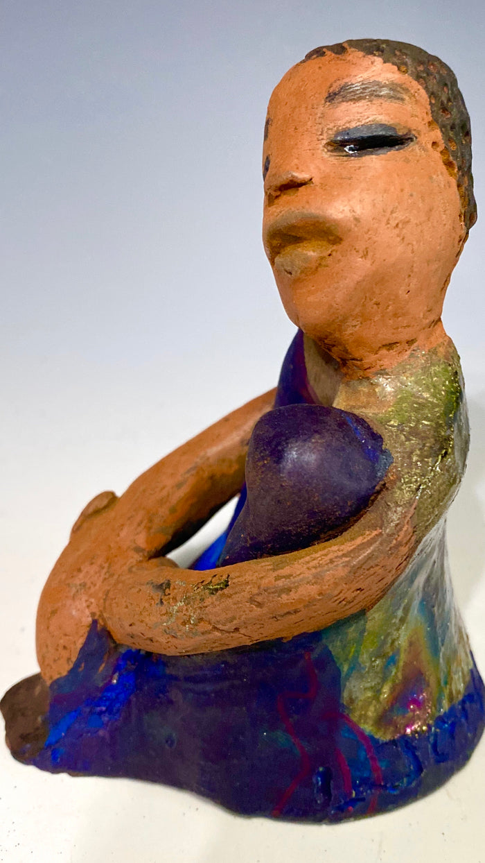 Paul is a Handsome Mischief Guy!  Do you see the wit in his face?  Paul stands 4.5"x 3" x 3" and weighs 6.9 ozs. He has a shimmery metallic tee shirt. Paul's complexion is honey brown. His arms are folded around his legs as he ponders another mischief moment!