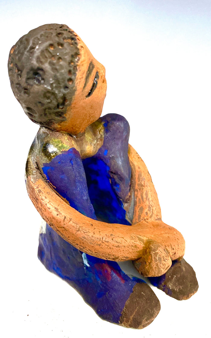 Paul is a Handsome Mischief Guy!  Do you see the wit in his face?  Paul stands 4.5"x 3" x 3" and weighs 6.9 ozs. He has a shimmery metallic tee shirt. Paul's complexion is honey brown. His arms are folded around his legs as he ponders another mischief moment!