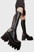 Sleek Sensations
  
  Ready Chunky Platform Knee High Boots in Black faux leather. These black vegan Platform Boots feature on our chunky platform sole, simple steps with exceptional comfort! Made with eco-friendly materials and 100% cruelty-free, these platform boots are as ethical as they are comfortable!
  
  
  - Platform Height: 3.3 inch
  - Black zipper 
  - Chunky Platform sole
  - Round Toe
  - 100% vegan 
  
  SKU: LMF 1986 - BlackPU