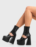 RING ME
  
  Ring Me Platform Ankle Boots Ankle Boots in Black faux leather. These platform boots feature a minimalist look with a cut out design, keeping it nice and classy. Made with eco-friendly materials and 100% cruelty-free, these platform boots are as ethical as they are chic.
  
  - Platform Height
  - calf length
  - Cut out design
  - Silver circle buckle
  - Flared heel
  - High Heel
  - 100% vegan 
  
  SKU: LMF 3354 - BlackPU