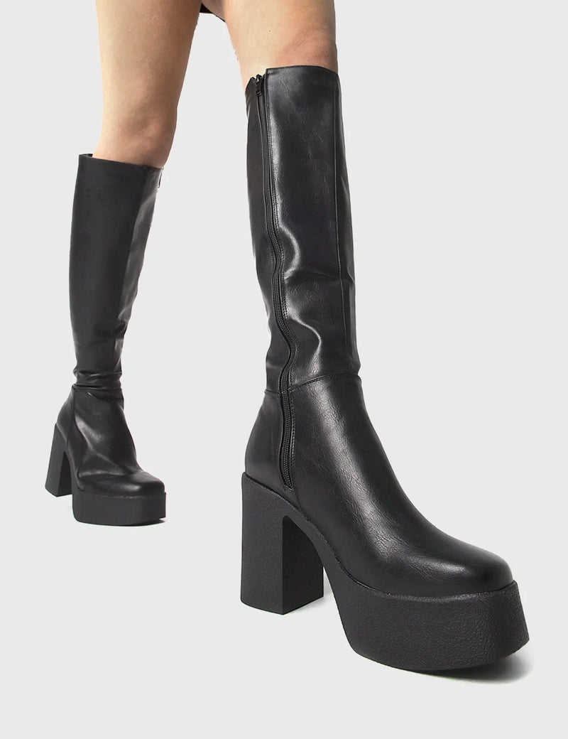THE TRENDING ONE
  
  Slick Nicks Platform Knee High Boots in Black faux leather. These Black vegan Boots feature an elegant minimalist design and a Platform sole and heel, perfect for adding height and style to any outfit. Made with eco-friendly materials and 100% cruelty-free, these boots are as ethical as they are stylish.
  
  
  - Platform Height: 1.25 inch
  - Heel Height: 4 inch
  - Knee High length
  - Black zipper 
  - Platform sole
  - Square toe 
  - 100% vegan 
  
  SKU: LMF 0856 - BlackPU