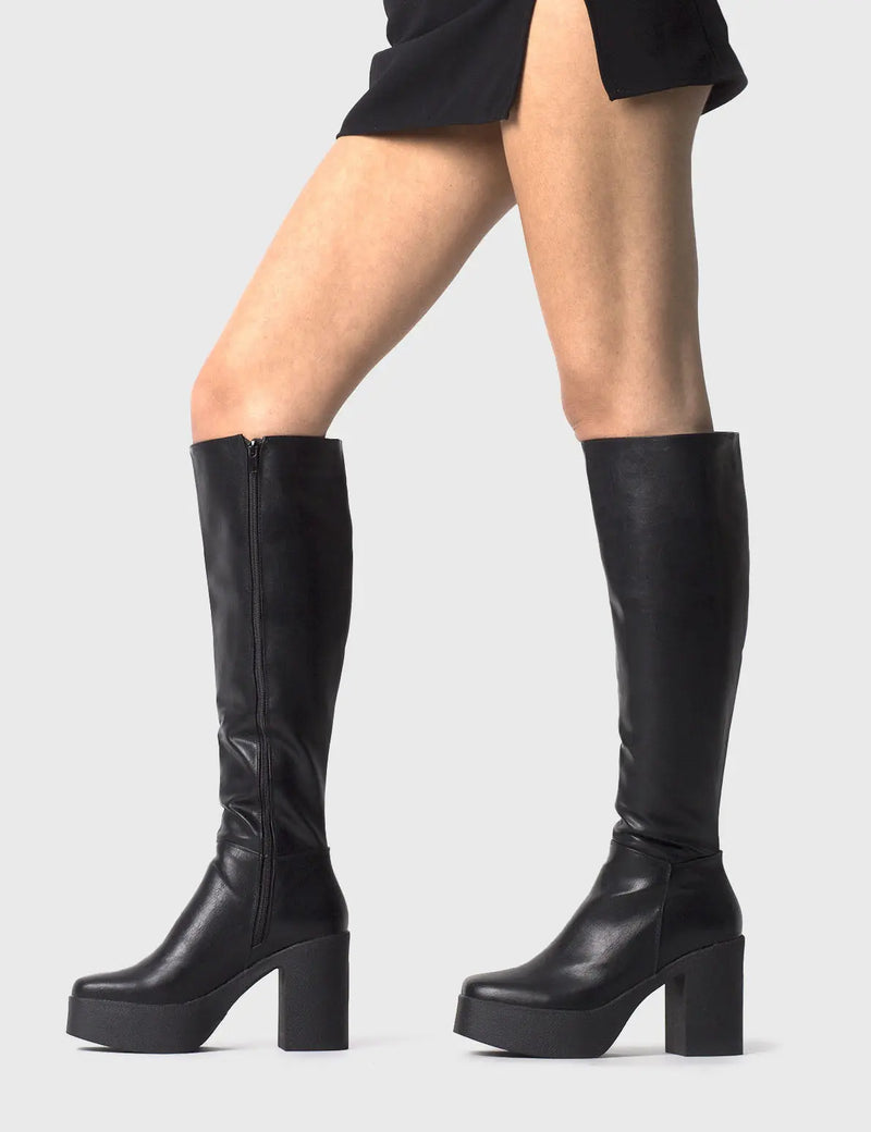 THE TRENDING ONE
  
  Slick Nicks Platform Knee High Boots in Black faux leather. These Black vegan Boots feature an elegant clutter free design and a Platform sole and heel, perfect for adding height and style to any outfit. Made with eco-friendly materials and 100% cruelty-free, these boots are as ethical as they are stylish.
  
  
  - Platform Height: 1.25 inch
  - Heel Height: 4 inch
  - Knee High length
  - Black zipper 
  - Platform sole
  - Square toe 
  - 100% vegan 
  
  SKU: LMF 0856 - BlackPU