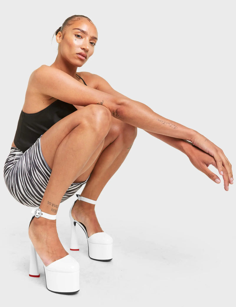 LOVE CYCLE
  
  Someday Platform Heels in White patent. These vegan heels feature a heart shaped heel with a red heart at the bottom, Also features a very classy adjustable ankle strap with a studded buckle. Made with eco-friendly materials and 100% cruelty-free, these heels are as ethical as they are loving!
  
  
  - Platform Height: 5.5 CM
  - Heel Height: 14 CM
  - Silver Studded Buckle
  - Silver eyelets
  - Heart shaped heel
  - Red heel sole
  - Rounded toe
  - 100% vegan
  
  LMF 4461 - WhitePAT