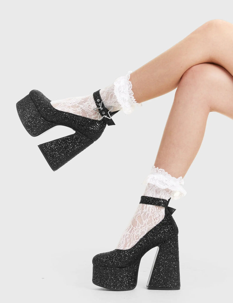 SHINE BRIGHT
  
  Starlight Platform Heels in Black glitter. These platform boots feature a silver star buckle with a flared heel, keeping it nice and classy. Made with eco-friendly materials and 100% cruelty-free, these platform boots are as ethical as they are chic.
  
  - Platform Height
  - Silver Heart buckles
  - Adjustable straps
  - Black Glitter
  - Flared heel
  - High Heel
  - 100% vegan 
  
  SKU: LMF 3348 - BlackGlitter