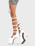 ROYAL TEA
  
  Still Reigning Platform Knee High Boots in White faux leather. These vegan Boots feature siz adjustable white straps with silver heart shaped buckles and silver eyelets with high heel that features a red heart at the bottom. Walk like royalty.
  
  - Platform Height: 6 CM
  - Heel Height: 14 CM
  - Six Adjustable Straps
  - Cut-out Design
  - Knee High Length
  - Silver Heart Buckles
  - Silver Eyelets
  - Platform Sole
  - Round Toe
  - 100% Vegan
  
  SKU: LMF 4645 - WhitePU