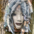 Summer has a white complexion and ruby red lips! She is 6”x 8”" and weighs 2.1 lbs. Summer has over 30 handmade raku fired beads. She has over 80 feet of coiled 16 and 24 gauge wire hair.