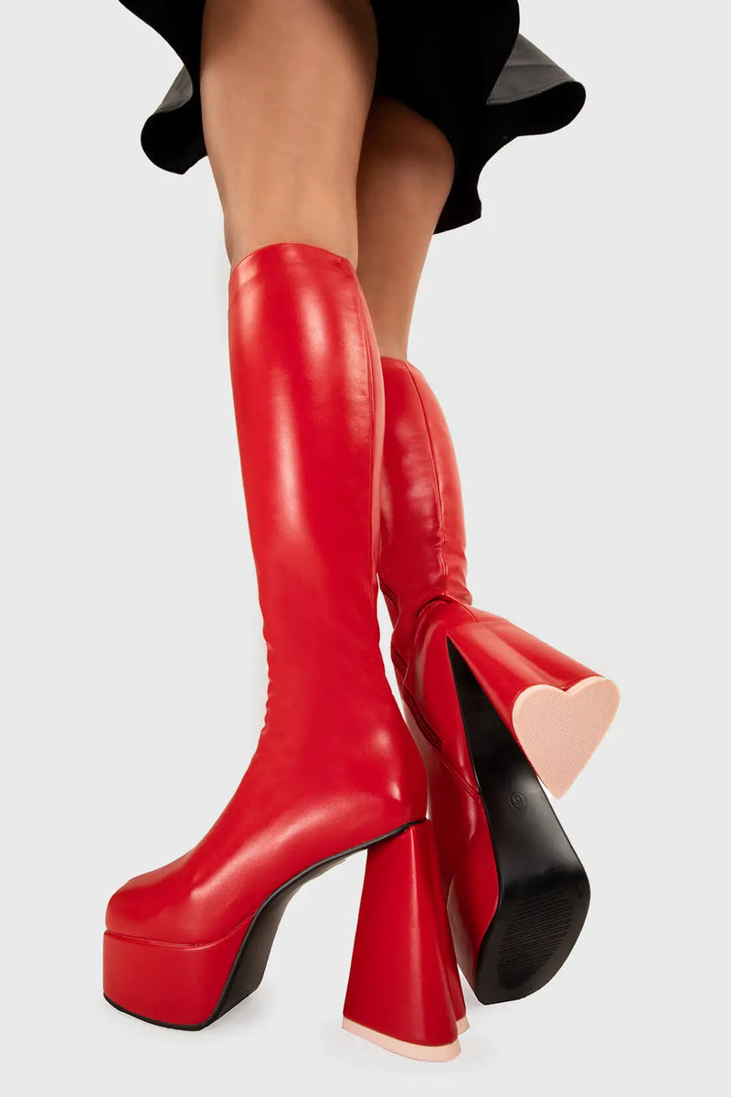 LOVEABLE 
  
  Sweet Talker Platform Knee High Boots in Red faux leather. These platform boots feature a minimalist look with a heart shaped heel, keeping it nice and classy. Made with eco-friendly materials and 100% cruelty-free, these platform boots are as ethical as they are chic.
  
  - Platform Height
  - Knee length
  - Heart shaped heel
  - Pink sole
  - Red zip
  - High Heel
  - 100% vegan 
  
  SKU: LMF 3313 - RedPU