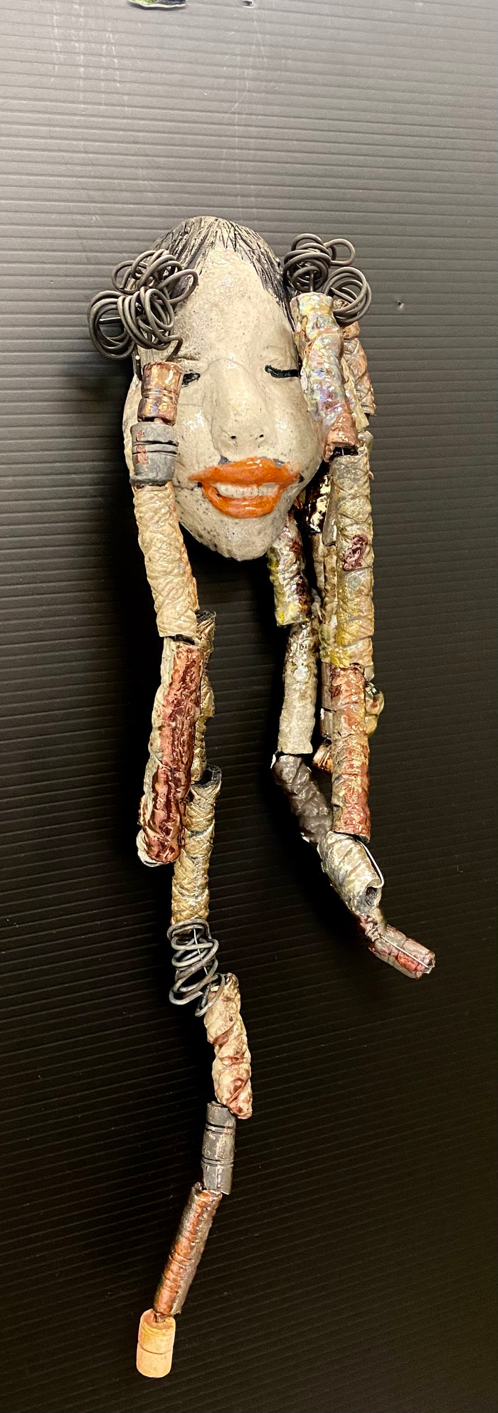 I started making art soon after seeing authentic African artwork at the Smithsonian Museum of African Art. I was in total awe.  Trinity was inspired by my visit there.  Trinity is 5”x 13” and weighs 11ozs. She has an off white complexion with ruby red lips. Trinity has five dreads of beads and spiral wire coils of hair. She is ready to be installed in your home!
