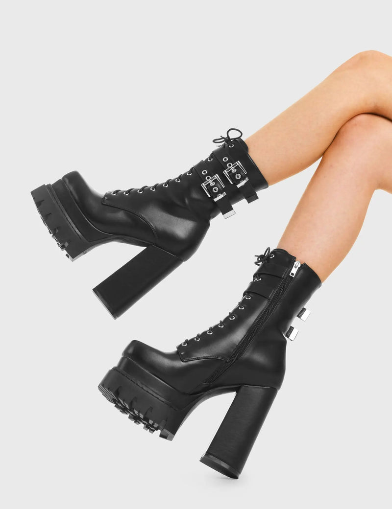 READY FOR COMBAT
  
  Wannabe Platform Ankle Boots in Black faux leather. These vegan western Boots feature two adjustable buckled straps and unique solid heel with rounded toe, a true badass . Made with eco-friendly materials and 100% cruelty-free, these boots are as ethical as they are timeless!
  
  
  - Heel Height 
  - Two adjustable Black straps
  - Silver eyelets
  - Silver Buckles 
  - Rubber grip sole
  - Rounded toe 
  - 100% vegan 
  
  SKU: LMF 3979 - BlackPU