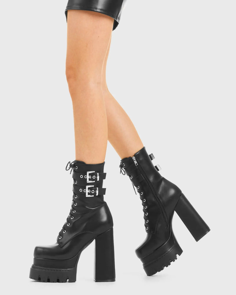 READY FOR COMBAT
  
  Wannabe Platform Ankle Boots in Black faux leather. These vegan western Boots feature two adjustable buckled straps and unique solid heel with rounded toe, a true badass . Made with eco-friendly materials and 100% cruelty-free, these boots are as ethical as they are timeless!
  
  
  - Heel Height 
  - Two adjustable Black straps
  - Silver eyelets
  - Silver Buckles 
  - Rubber grip sole
  - Rounded toe 
  - 100% vegan 
  
  SKU: LMF 3979 - BlackPU