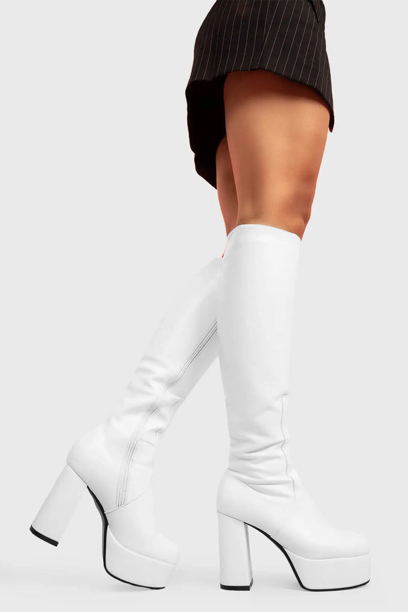 THE TIMELESS ONE
  
  Whatta Showdown Wide calf Platform Knee High Boots in White faux leather. These White vegan Boots feature an elegant, minimalist design and a Platform sole and heel, perfect for adding height and style to any outfit. Made with eco-friendly materials and 100% cruelty-free.
  
  - Platform Height: 1.25 inch
  - Heel Height: 4.2 inch
  - Knee High length
  - Wide fit 
  - White zipper 
  - Platform sole
  - Round toe 
  - 100% vegan 
  
  SKU: LMF 0916 - WhitePU - WIDE FIT