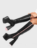 PEACE AND LOVE
  
  Wild Child Platform Knee High Boots in Black Faux Leather. These vegan western Boots feature heart shaped heel, with a red sole and shark teeth grips, very classy. Made with eco-friendly materials and 100% cruelty-free, these boots are as ethical as they are edgy!
  
  
  - Chunky Platform heels
  - Knee length
  - Shark teeth grip
  - Heart shaped heel
  - Pink heel sole
  - Rounded toe 
  - 100% vegan 
  
  SKU: LMF 3634 - BlackPU/Pink