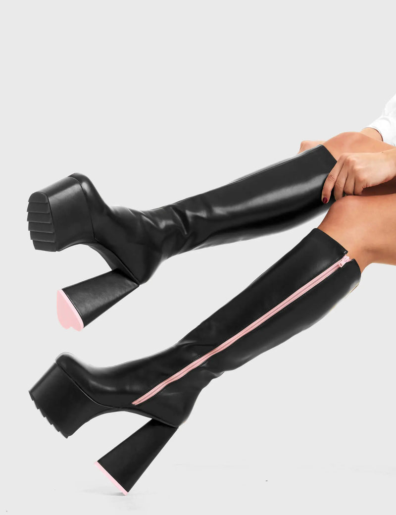 PEACE AND LOVE
  
  Wild Child Platform Knee High Boots in Black Faux Leather. These vegan western Boots feature heart shaped heel, with a red sole and shark teeth grips, very classy. Made with eco-friendly materials and 100% cruelty-free, these boots are as ethical as they are edgy!
  
  
  - Chunky Platform heels
  - Knee length
  - Shark teeth grip
  - Heart shaped heel
  - Pink heel sole
  - Rounded toe 
  - 100% vegan 
  
  SKU: LMF 3634 - BlackPU/Pink