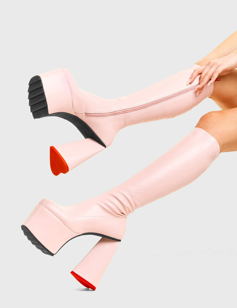 PEACE AND LOVE
  
  Wild Child Platform Knee High Boots in Pink Fitted Faux Leather. These vegan western Boots feature heart shaped heel, with a red sole and shark teeth grips, very classy. Made with eco-friendly materials and 100% cruelty-free, these boots are as ethical as they are edgy!
  
  
  - Chunky Platform
  - Knee length
  - Shark teeth grip
  - Fitted feel
  - Heart shaped heel
  - Red heel sole
  - Rounded toe 
  - 100% vegan 
  
  SKU: LMF 3633 - PinkStretchPU